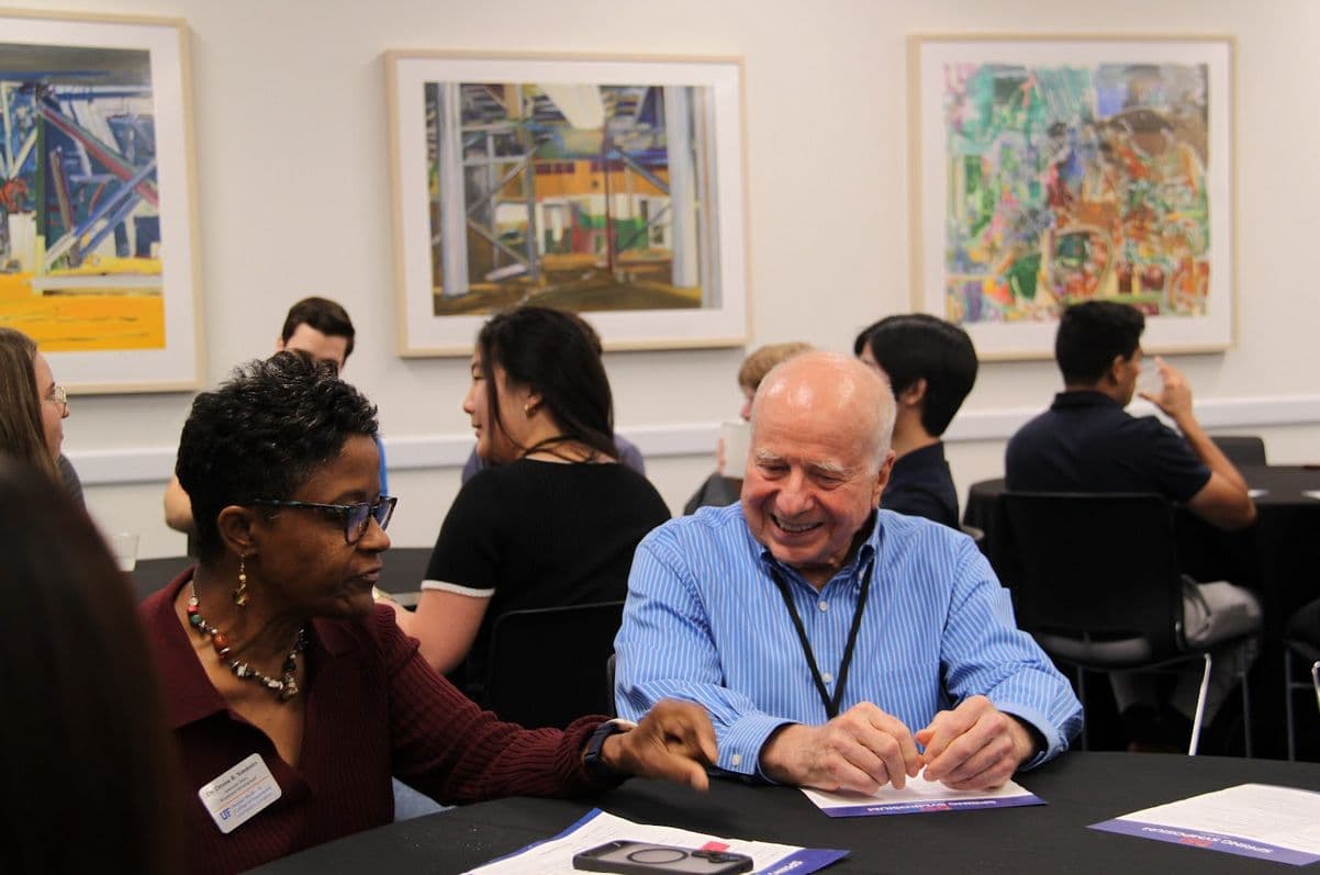 Attendees talking at round tables during a networking session